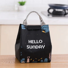 Black lunch bag with 'Hello Sunday' text on a wooden surface