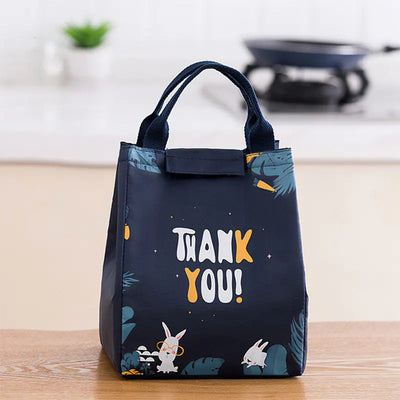 Black lunch bag with 'THANK YOU!' text and animal illustrations on a wooden surface.